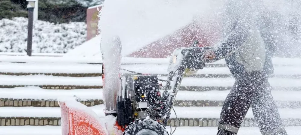 person plowing snow with a snow plow